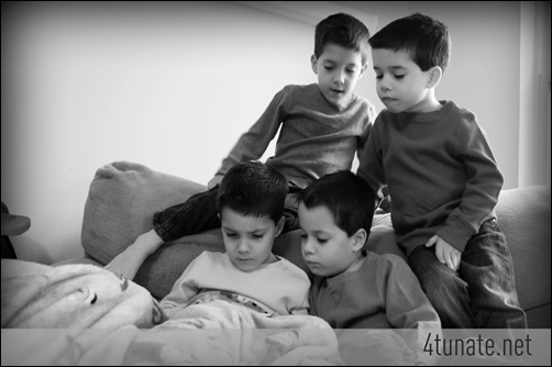 four brothers reading together on the couch