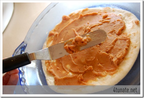 spreading refried beans for mexican layered casserole