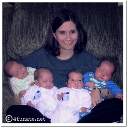 mother holding quadruplets babies all at one time