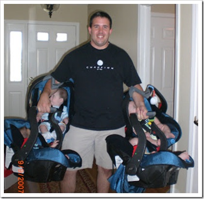 dad carrying all four carseats with quadruplets